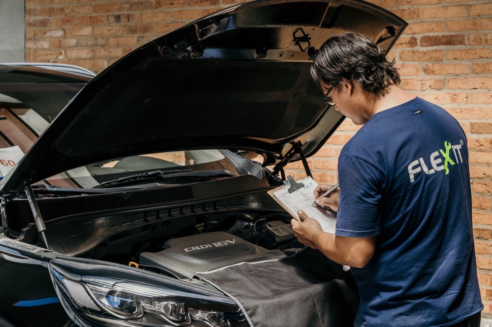 Técnico de FLEXIT revisando el motor con el capó abierto